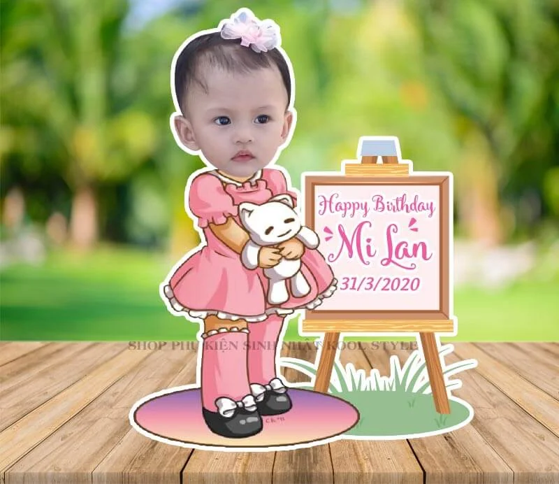 chibi be gai om bup be dung canh bang sinh nhat Chibi bé gái ôm búp bê đứng cạnh bảng sinh nhật