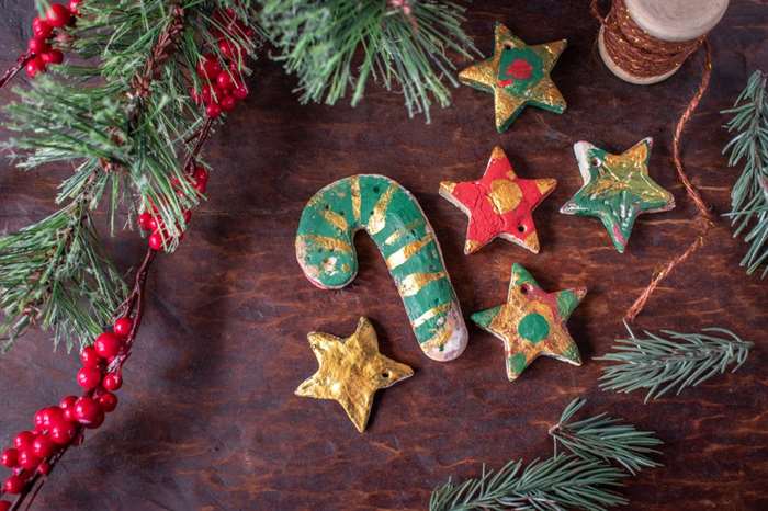 Hand painted Christmas salt dough ornaments on festive wood table.