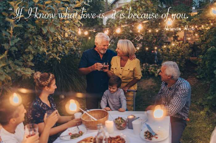 Photo of a senior couple, celebrating their anniversary with family, having a dinner outdoors in the back yard