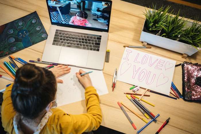 little girls drawing together over video chat