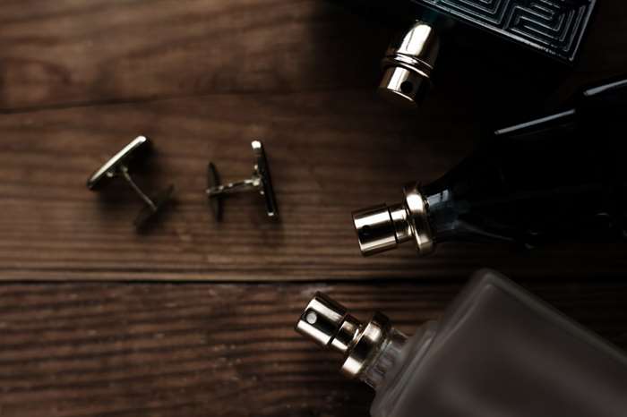 Stylish mens business accessories: cologne and cufflinks.