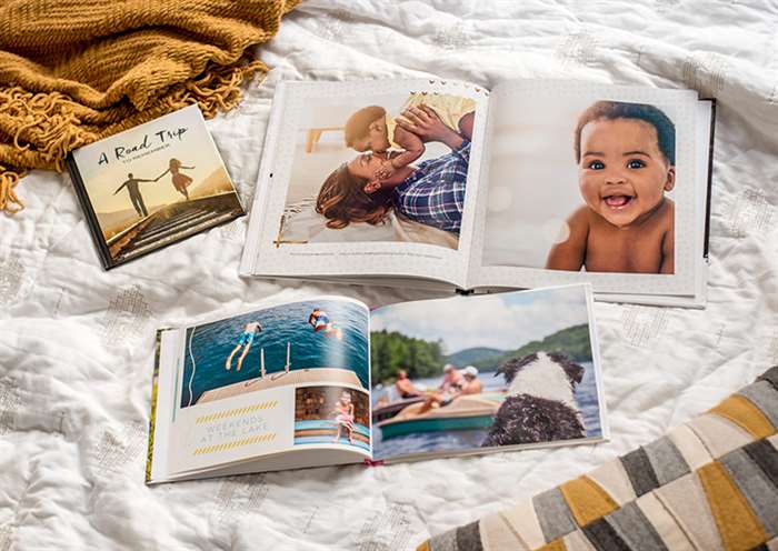 three photo books in different photo book sizes on a bed