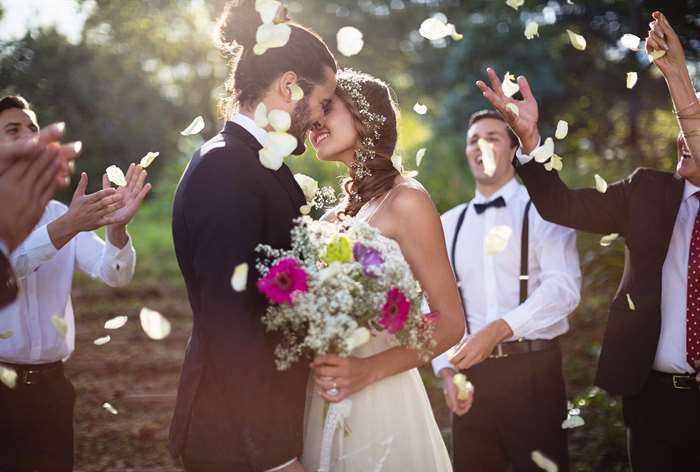 wedding invitation wording couple kissing with flowers around them