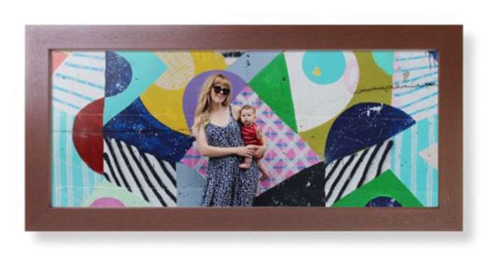 Bản in toàn cảnh rộng với ảnh mẹ và em bé đang tạo dáng trước bức tường tranh tường
