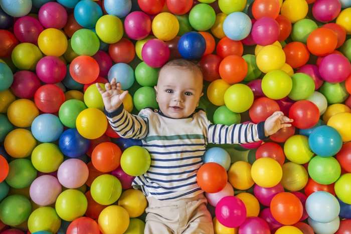 cậu bé đang cười vui vẻ trong hố bóng trong bữa tiệc sinh nhật ở công viên giải trí trẻ em và trung tâm vui chơi trong nhà. 