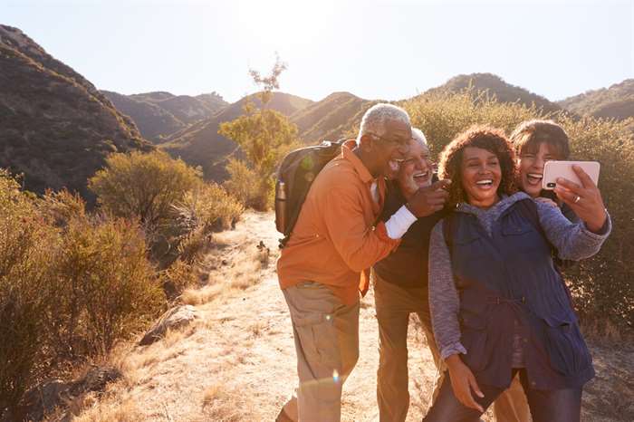 Best friends posing for selfie as they hike along trail in countryside together