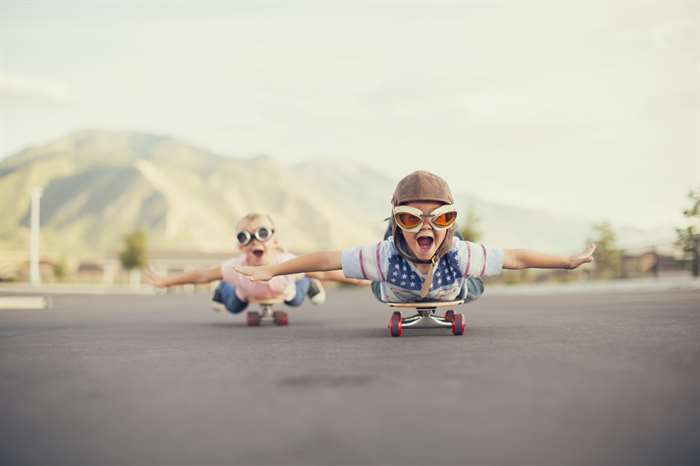 Young Boy and Girl Imagine Flying On Skateboard