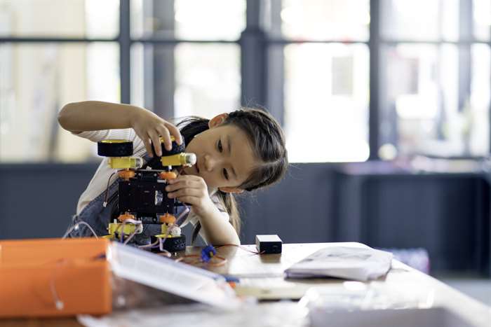 Young girl working on a robot design