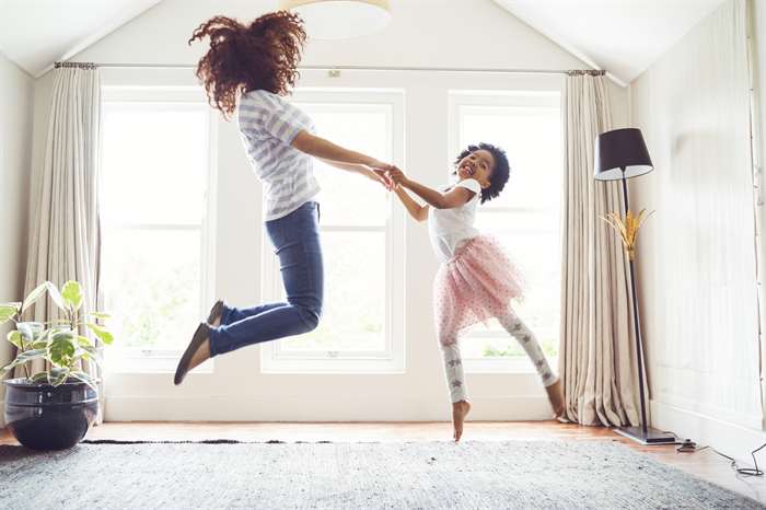 mother and child jumping and dancing at home