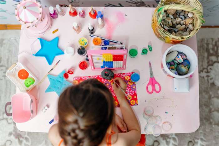 little girl is painting rocks