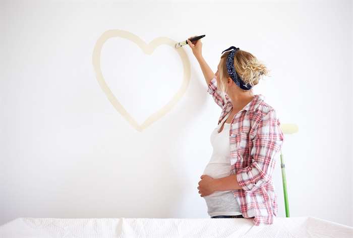 Người phụ nữ vẽ trái tim trên tường.