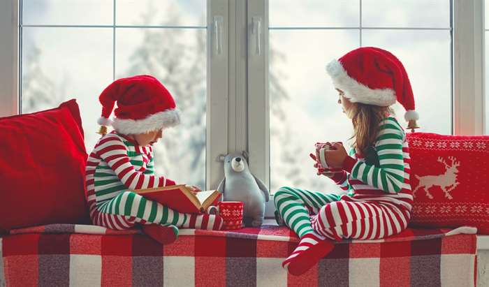 children girl and boy is sad on Christmas morning by the window