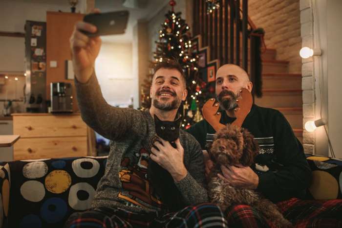 Cặp đôi đồng tính ăn mừng Giáng sinh tại nhà với thú cưng, chó và mèo của họ.