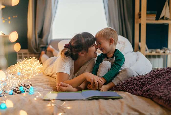 Mom and son laughing with story book.