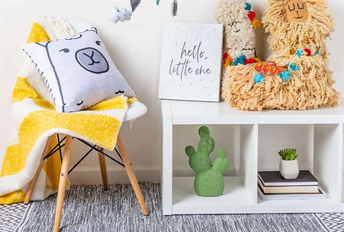 Blanket and pillow on chair next to cubby shelves.