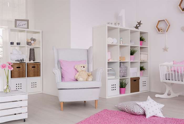 Armchair next to square shelves and pink rug.