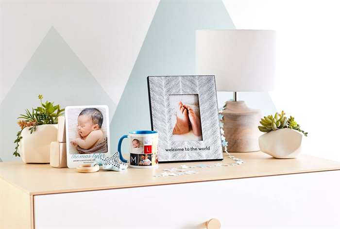 Dresser with picture frames, lamp, and plants.