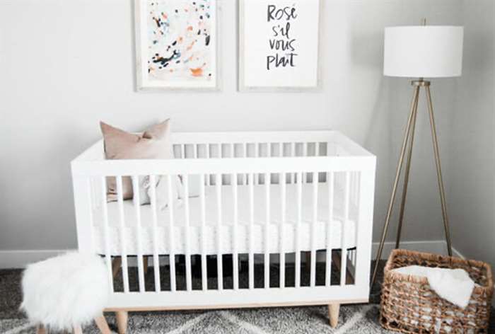 Gray and white nursery decor with crib. 