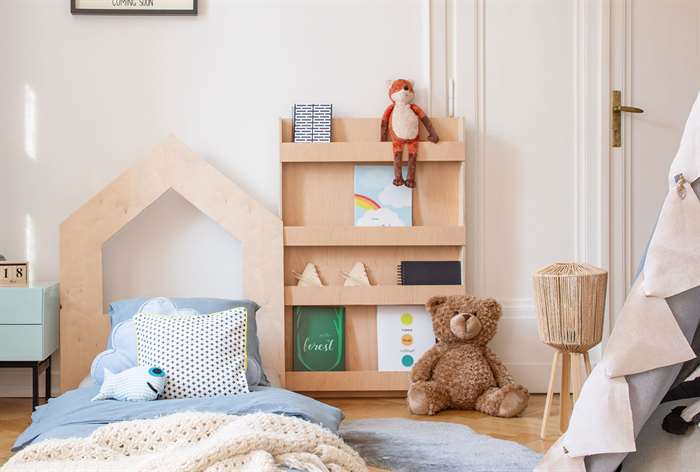 Magazine rack next to kid bed.