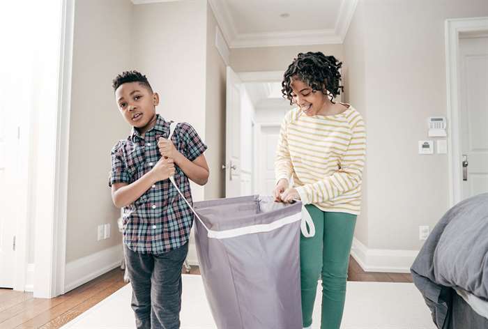 Two kids carrying laundry bag.