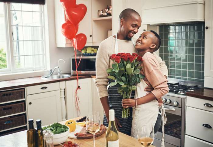 cute couple celebrating valentine's day cooking together a romantic dinner