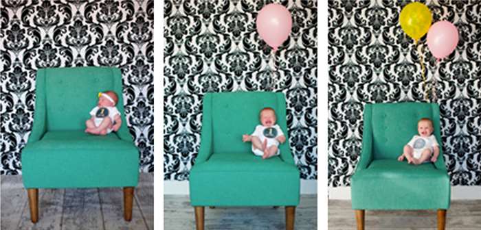 Em bé trong chiếc ghế màu xanh lá cây với bóng bay