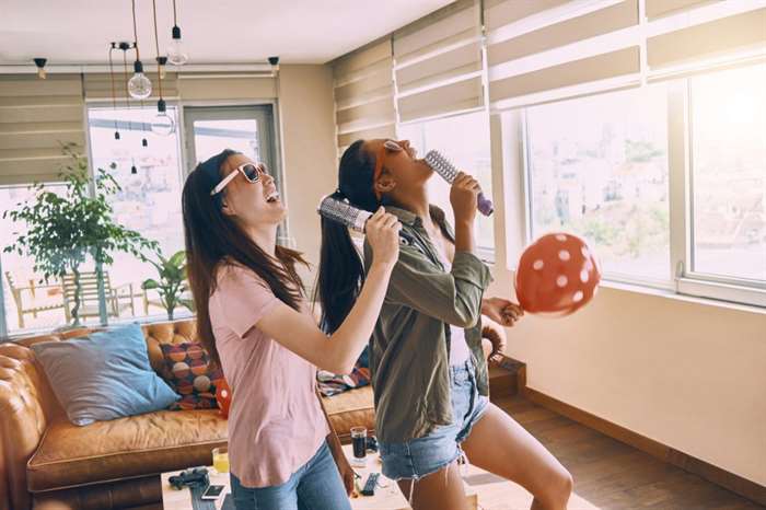 two cheerful friends singing and having fun