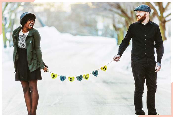 Couple holding bunting that says engaged