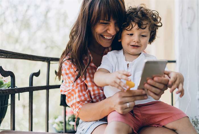 Mom and son smiling looking at phone.