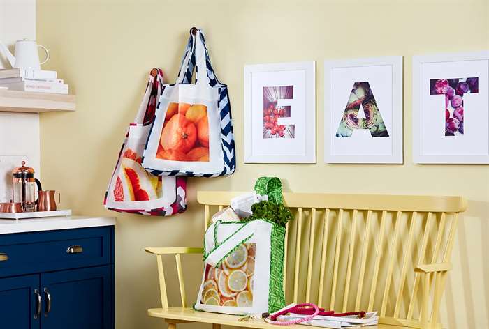 Monogrammed prints hanging above yellow bench.