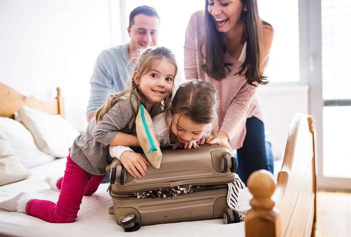 Family smiling and packing for a trip.