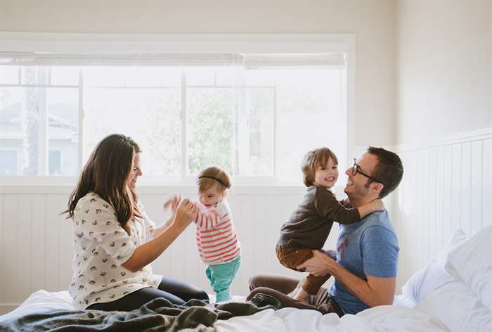 sibling photo ideas parents kids on bed