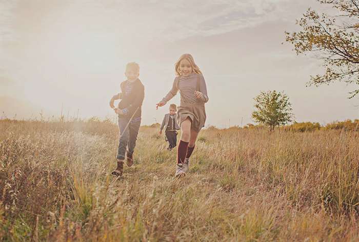 sibling photo ideas runnong through field