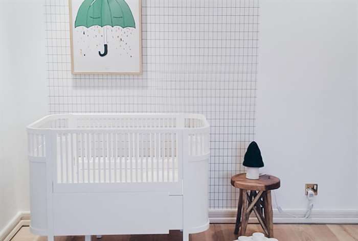 Minimalist white baby crib in nursery.