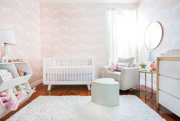 Pink and white nursery with bunny wallpaper.