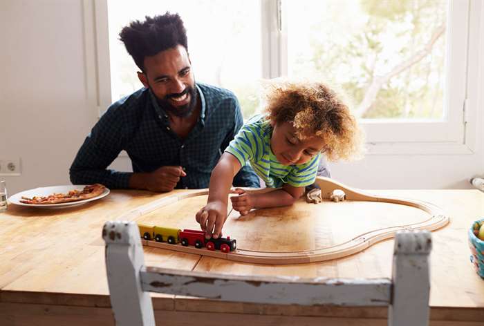 Father and son playing with train set.