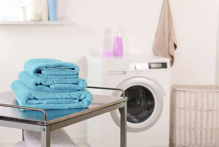 Metal rolling cart next to washer.