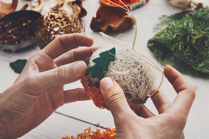 Making handmade craft Christmas ornaments and balls with felt spruce tree. background