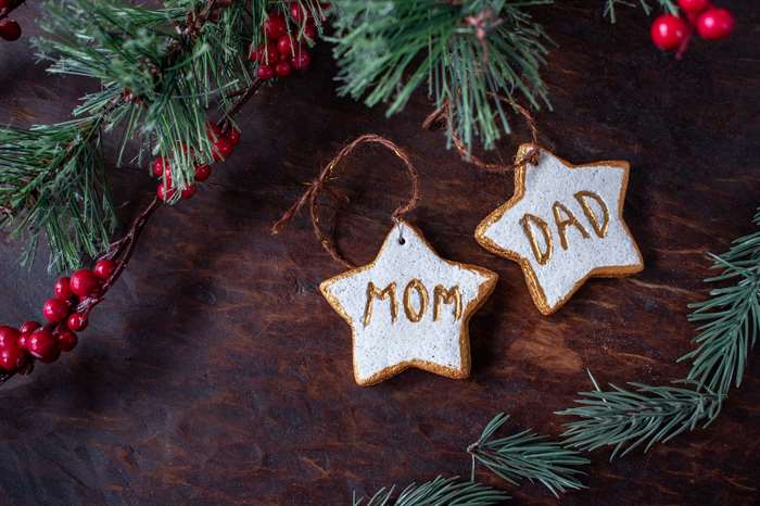 hand painted Christmas star ornaments for mom and dad on festive tree.