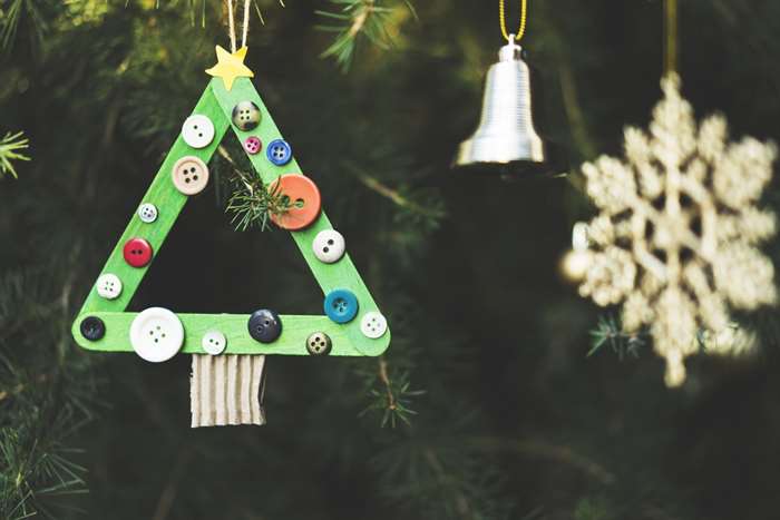 Homemade Christmas tree ornament made with ice cream sticks and buttons.