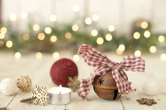 Christmas holiday rustic bell, natural fiber baubles, and decorations on old white wood background.