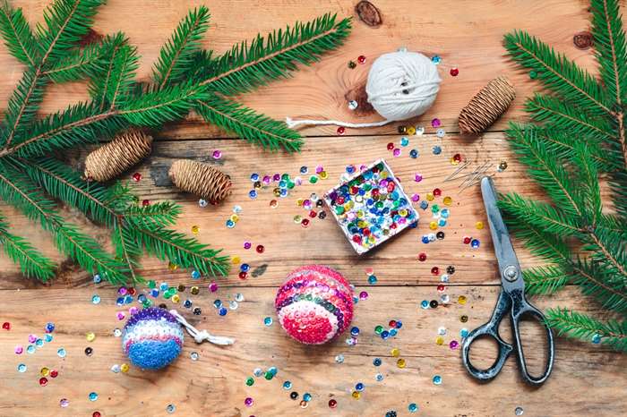 Making Christmas ornaments by pinning the sequins onto the ball.