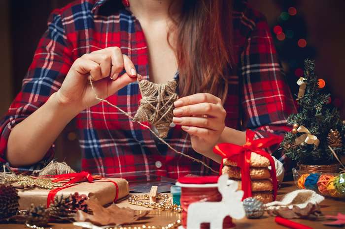 Woman creates a woolen star for her Christmas tree.