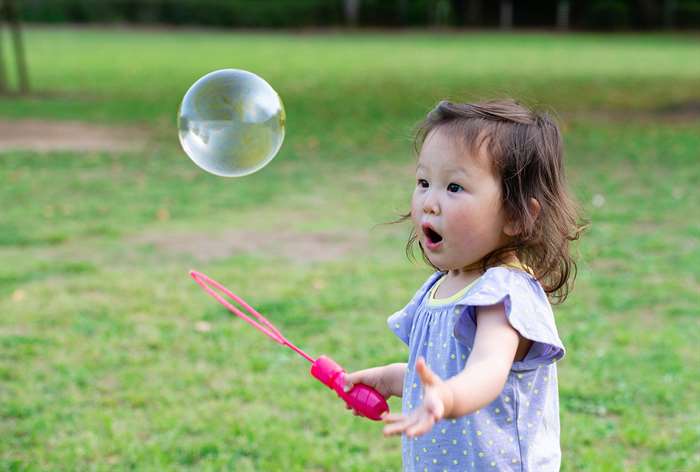 Toddler staring at bubbles.