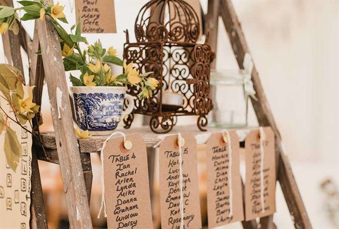 Handwritten tags hanging on wood shelf.