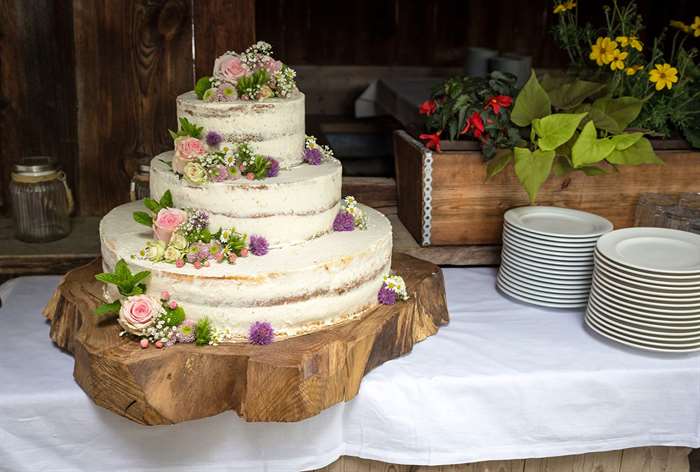 Crumb coat cake on wood tray.