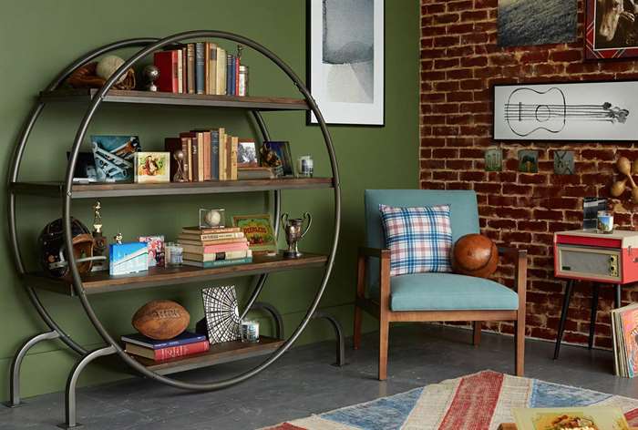 Round bookshelf next to blue chair.