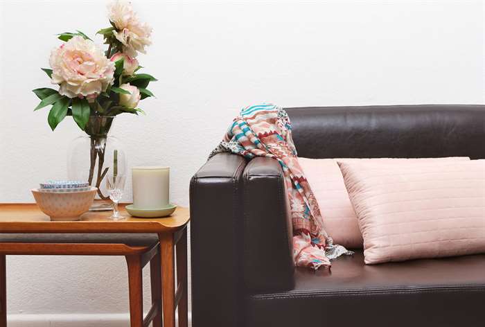 Brown leather couch with end table.