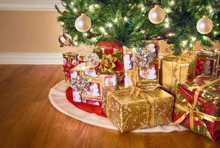 Red tree skirt with white felt border under tree.