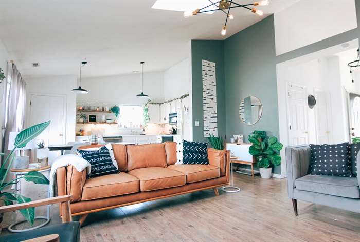 brown couch in living room with green accent wall.